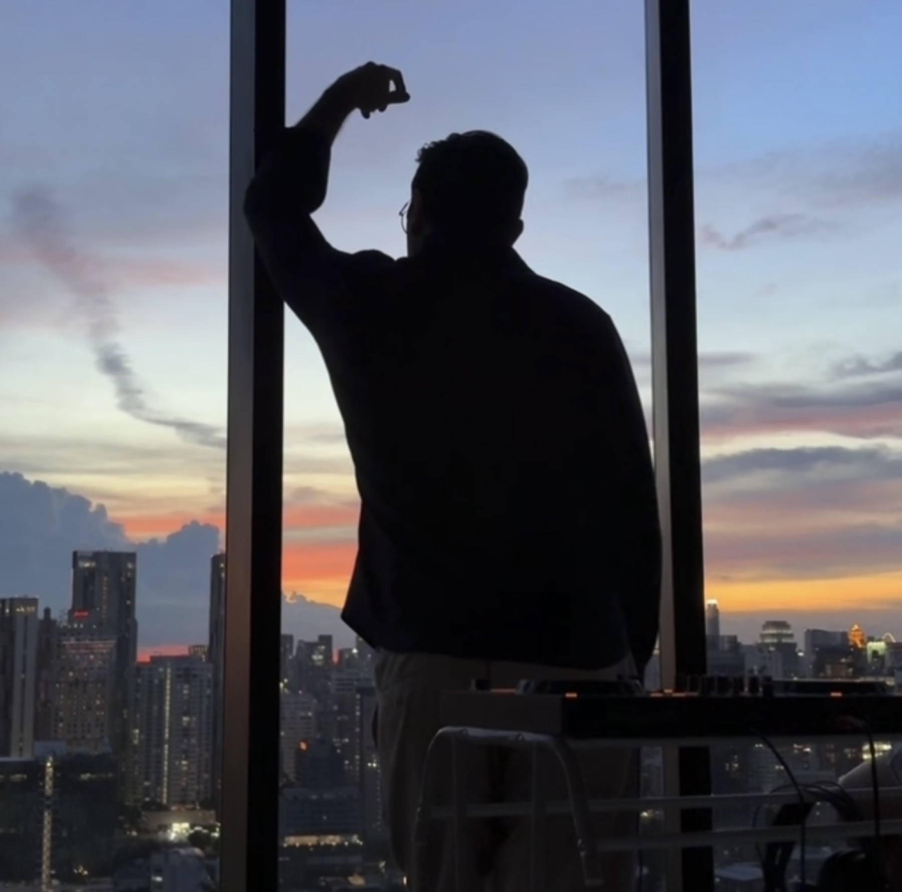 Mirarii silhouetted against the Bangkok skyline at sunset